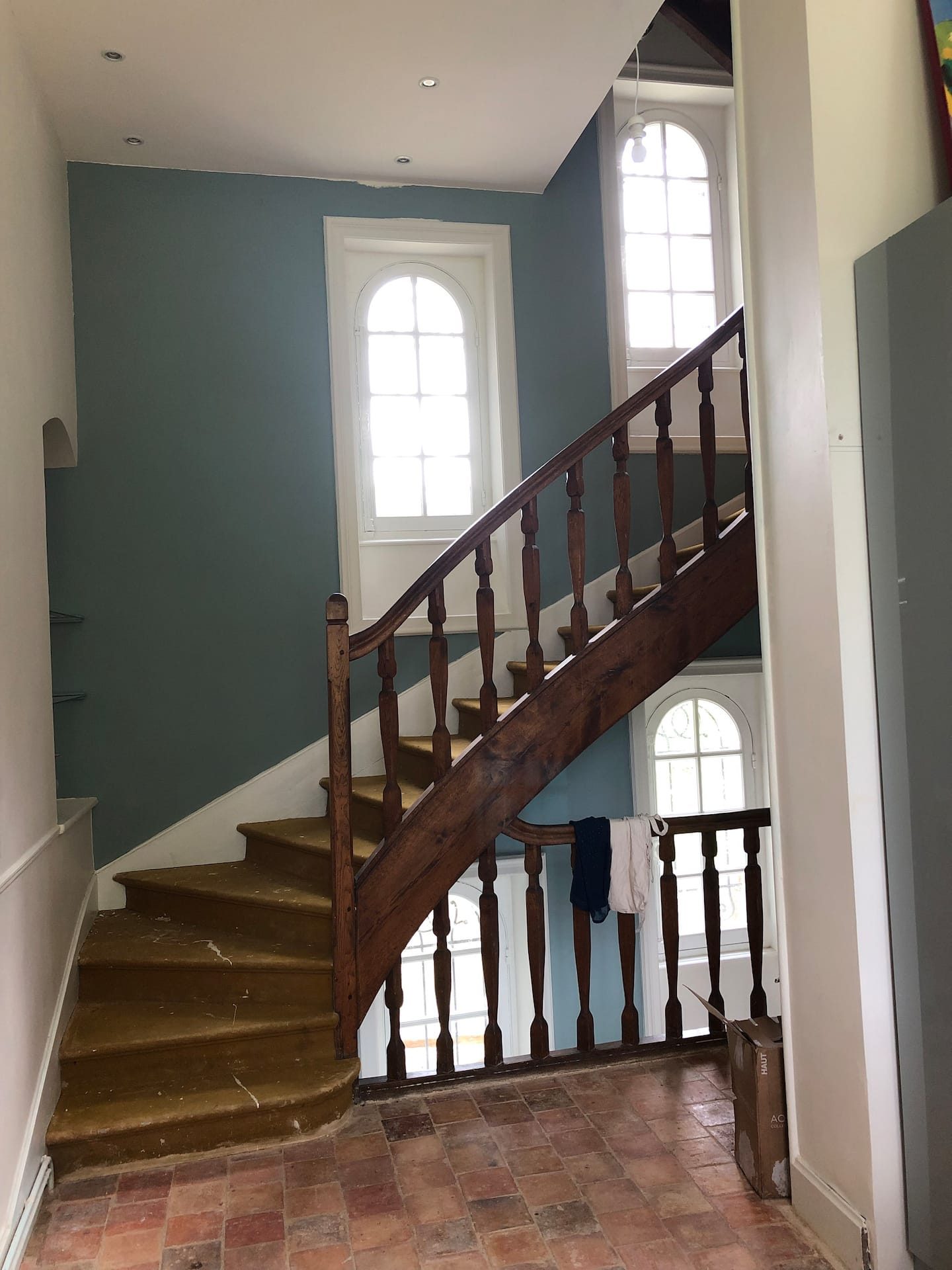 L’escalier de chêne et sa fenêtre cintrée